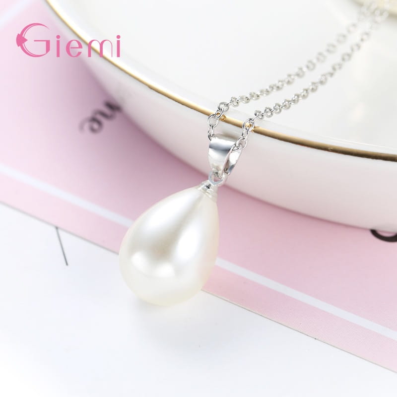 Un delicado collar de perlas de plata esterlina con un dije de perla blanca con forma de lágrima, suspendido de una fina cadena de plata.