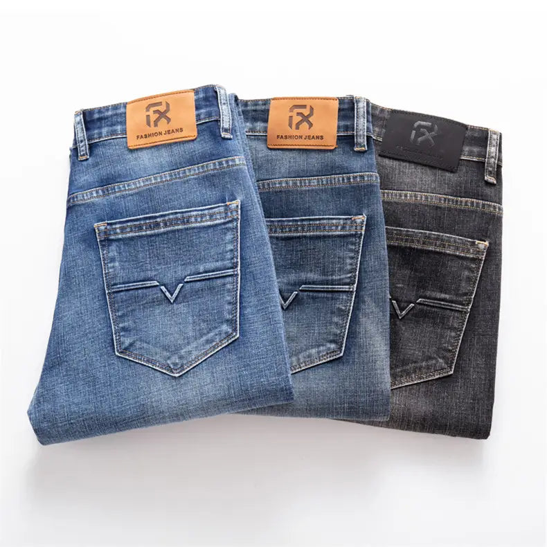 Trois paires de jeans en denim stretch pour hommes, coupe regular fit, en bleu moyen, en foncé et en noir, avec des empiècements en cuir marron portant la mention « fashion jeans » sur la ceinture.