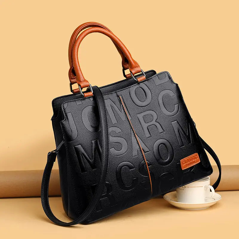 black crossbody handbag style1 style2 made of black pu leather with embossed lettering and brown handles in satchel design