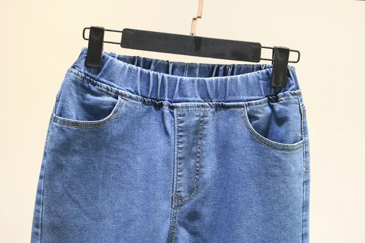 Jupe en denim bleu avec taille élastique et poches à l’avant, fabriquée à partir de denim bleu clair extensible adaptée à un port taille haute