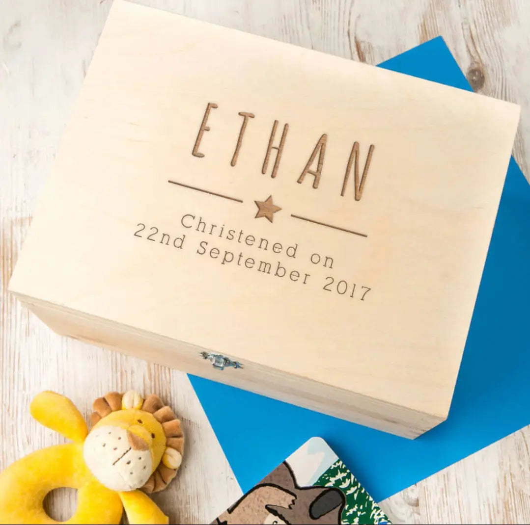 淡色の木製の個別に名入れした洗礼記念品保管箱。名「Ethan」と日付を刻印しており、行と行の間に小さな星を配置しています。