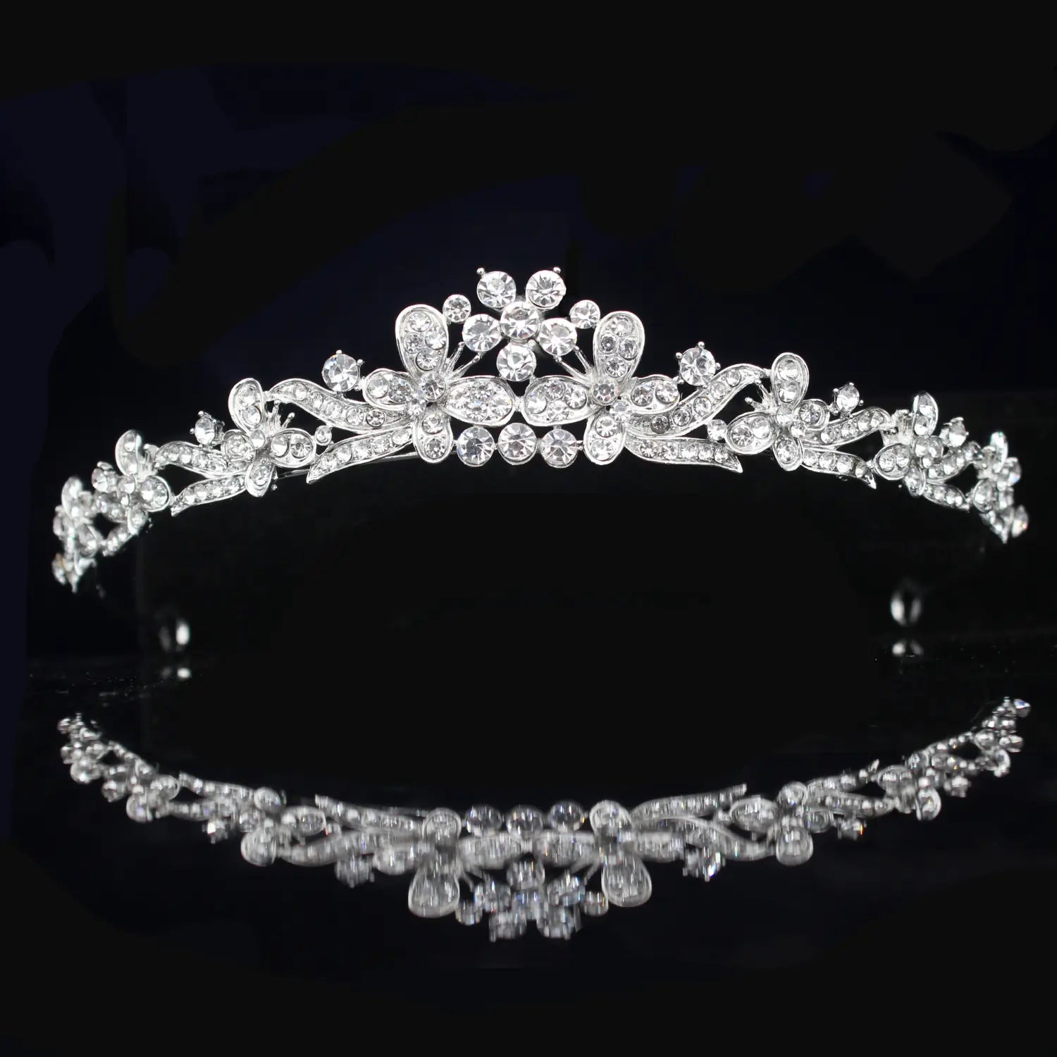 Una tiara de novia de cristal plateado brillante con diseños florales intrincados y cristales transparentes, adecuada para bodas.