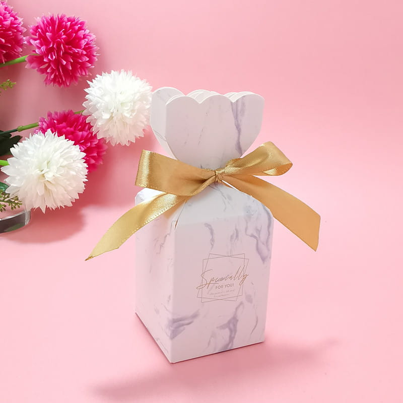 Eine Hochzeits-Gastgeschenkbox mit marmoriertem Weiß-Design und einer goldfarbenen Band-Schleife, vorn mit „Speziell für Sie“ bedruckt