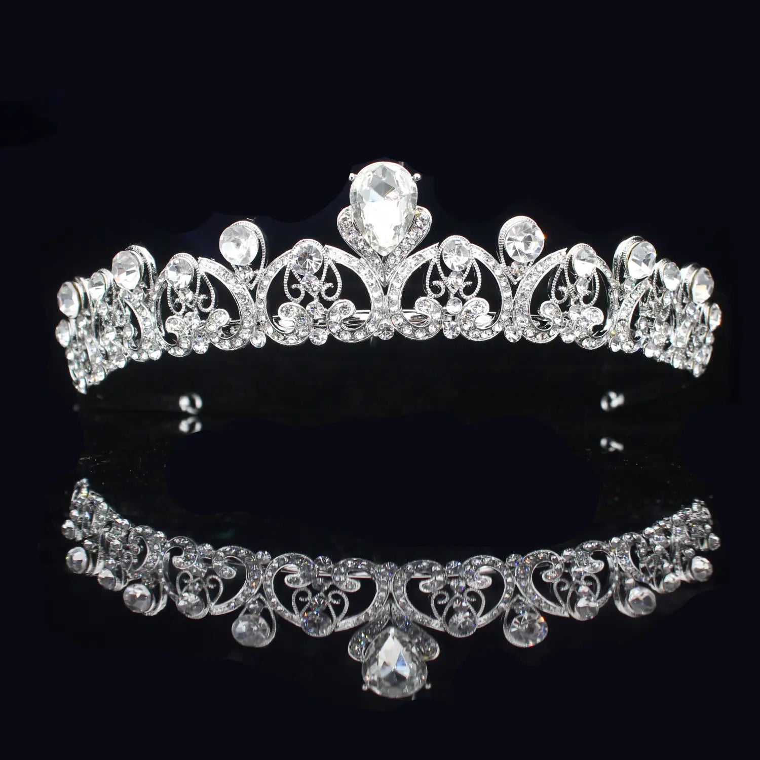 Una diadema de boda floral con tiara de novia de cristal plateado brillante, con filigrana intrincada y cristales transparentes, que cuenta con un llamativo centro con forma de gota.