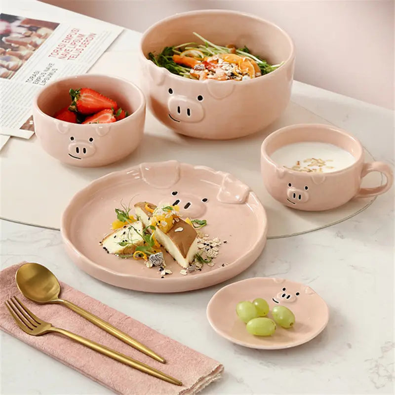 Pastel pink ceramic dinnerware set with pig face designs on bowls plates and cups featuring the cute pig ceramic dinnerware set.