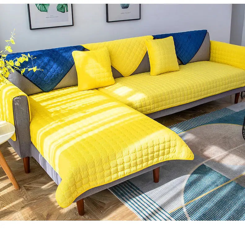 Housse de canapé antidérapante en velours côtelé matelassé jaune vif avec accents géométriques bleus et gris.