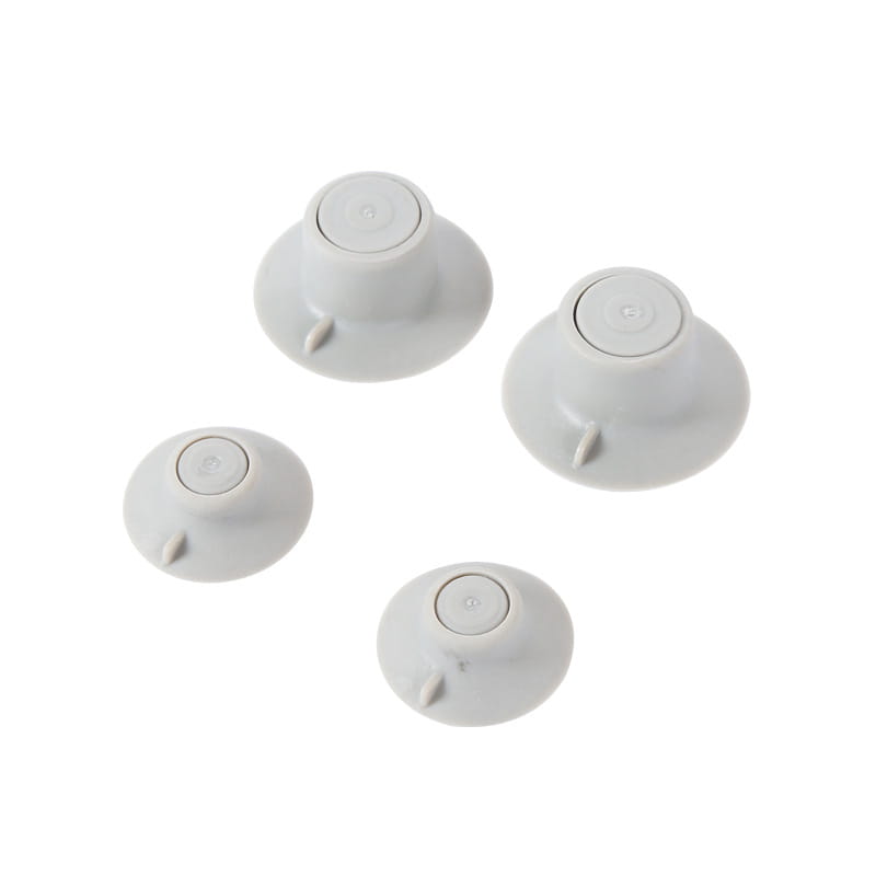 ensemble de quatre fixations à ventouse en plastique blanc, bases circulaires et petites languettes en saillie, conçues comme patins de réduction de la chaleur pour pieds de refroidissement d’ordinateur portable.