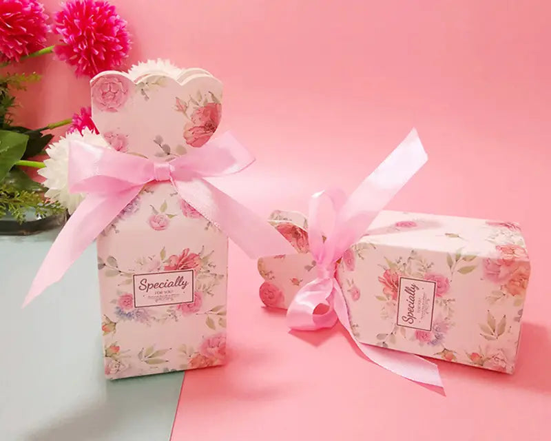 Blumige Hochzeits-Gastgeschenkboxen mit rosafarbenen Blumenmustern, herzförmigen Oberteilen und passenden Satinbändern