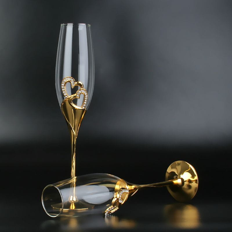 Elegant gold-finished wedding champagne flutes adorned with sparkling heart-shaped embellishments for toasting glasses set.