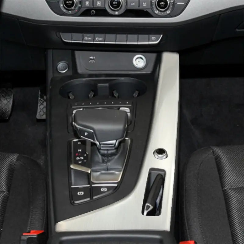 Automatischer Schalthebel mit silberner Zierkante, schwarzem Lederrand und Chrom-Details in der Einfassung des Audi A4 B9 A5 Schalthebel-Wandhalters für den Becherhalter.