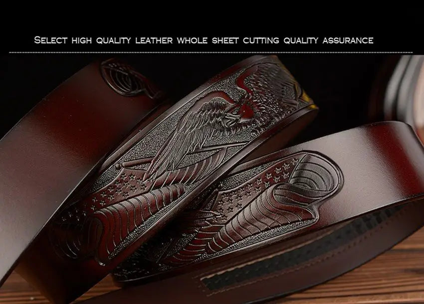 Ceinture à cliquet en cuir brun foncé pour homme, avec une boucle d’aigle finement gravée et une pierre d’accent rouge.