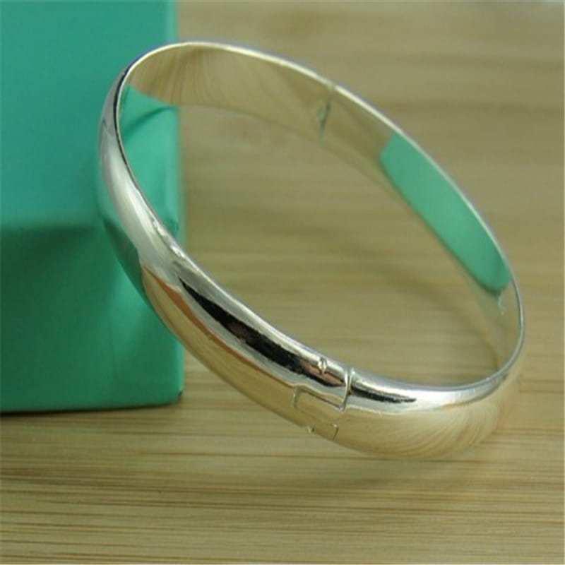 Una pulsera de plata pulida elegante, 925, brazalete abierto para mujer, con diseño liso y redondeado, y un mecanismo de cierre seguro, ideal como brazaletes pulseras mujer.