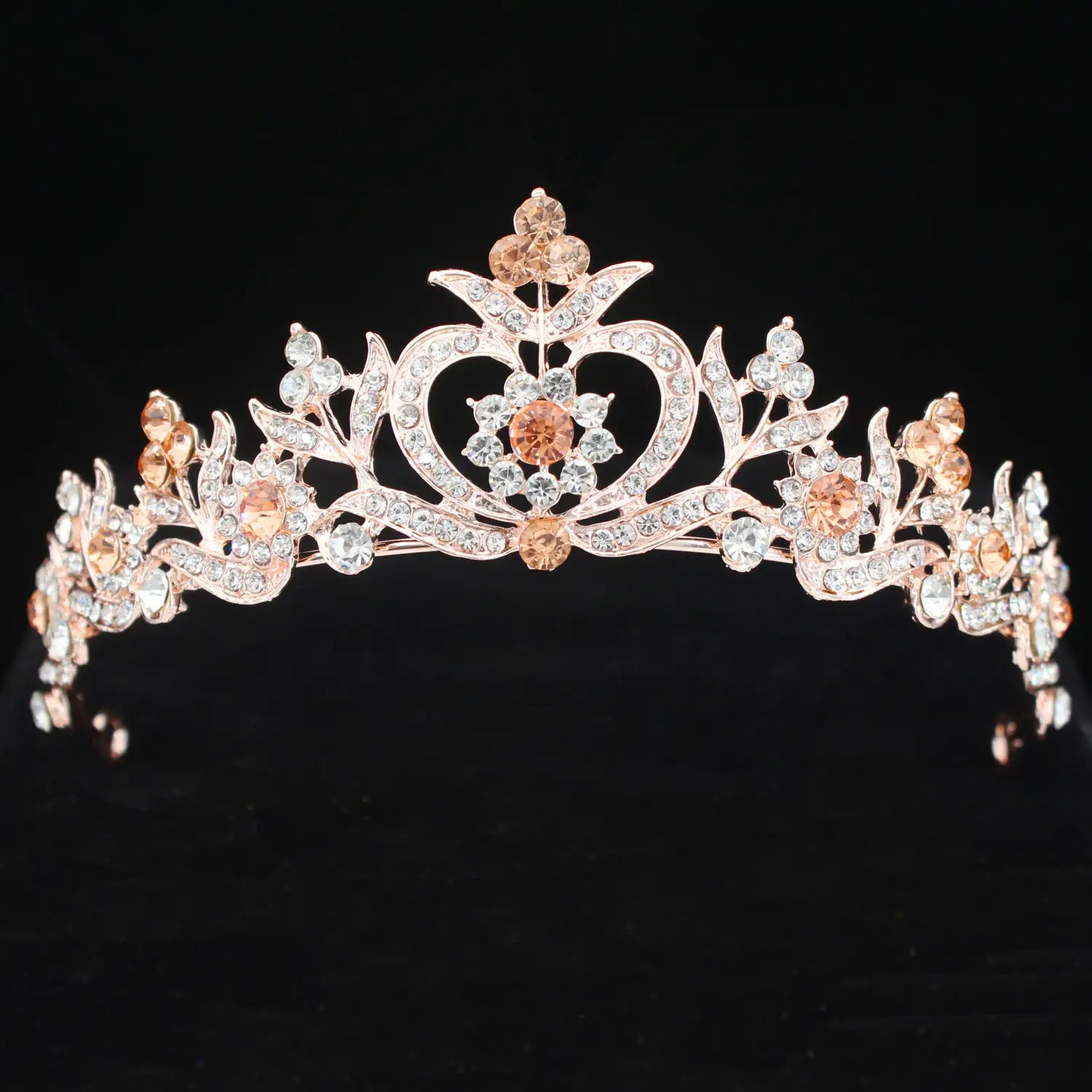 Una tiara de novia de cristal rosa dorado delicada con un diseño floral intrincado, adornada con cristales transparentes brillantes y cristales color ámbar cálidos para bodas.