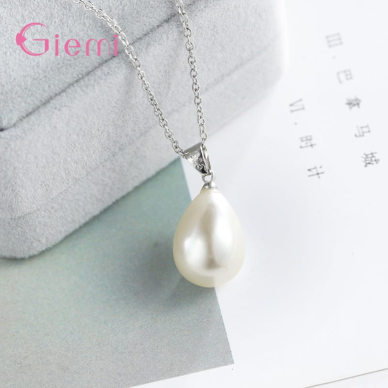 Conjunto de joyas de perlas de plata esterlina que presenta una delicada cadena de plata con un dije de perla blanca en forma de lágrima, con un brillo sutil.