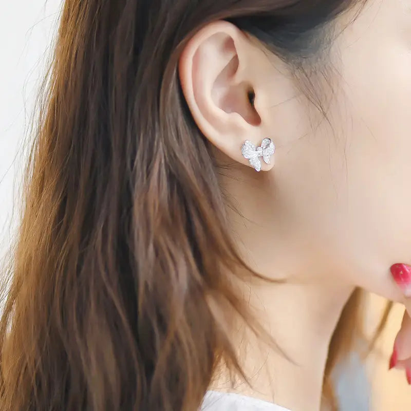 A delicate silver bow-shaped stud earring adorned with sparkling clear zircon crystals from the silver bowknot zircon necklace and earrings set.