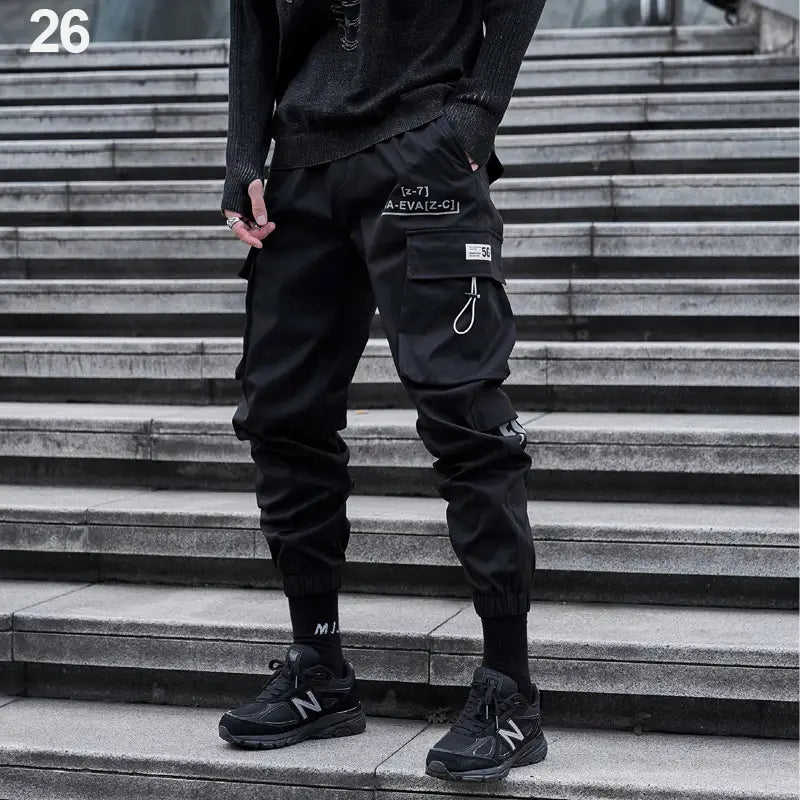 Herren schwarze taktische Cargo-Jogginghosen im Streetwear-Stil mit mehreren Taschen und weiß besticktem Text am Oberschenkel
