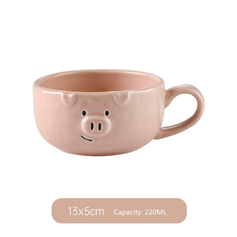 A blush pink ceramic mug shaped like a pig with black dot eyes snout and ears from the cute pig ceramic dinnerware set.
