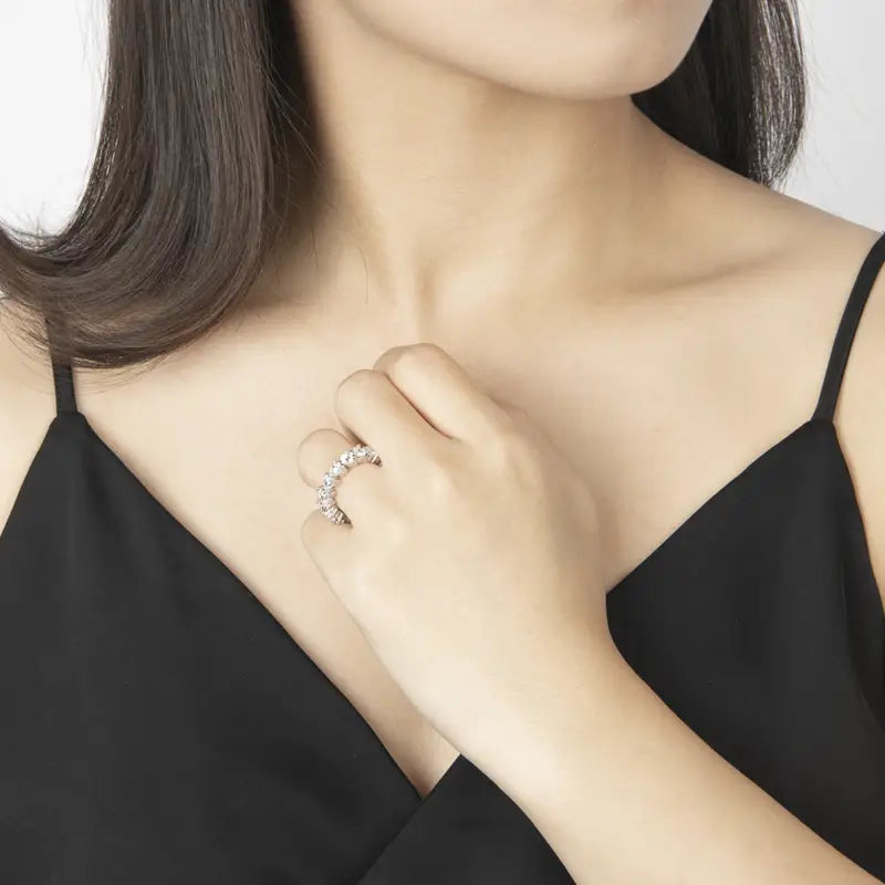 Une bague-bande en diamant étincelant, cœur en argent sterling, avec un sertissage argenté élégant, portée avec élégance au doigt du modèle.