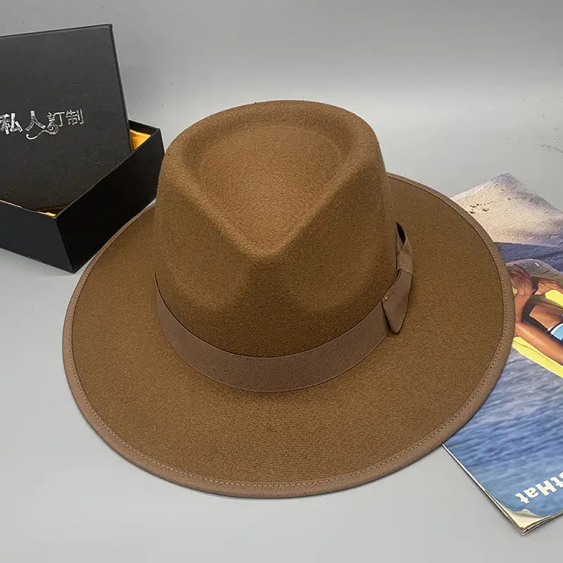 Brown unisex woolen felt fedora hat with matching band and bow and feather accent.