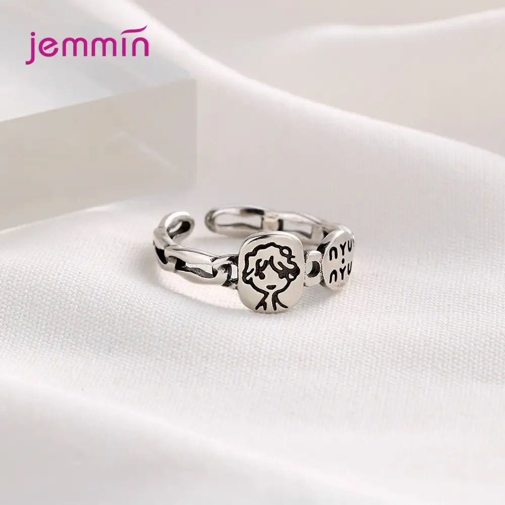Bague réglable à motif facial en argent sterling Jemmin, présentant une breloque en forme de visage de style dessin animé et un texte gravé sur les maillons, avec une conception à dos ouvert pour un ajustement facile.