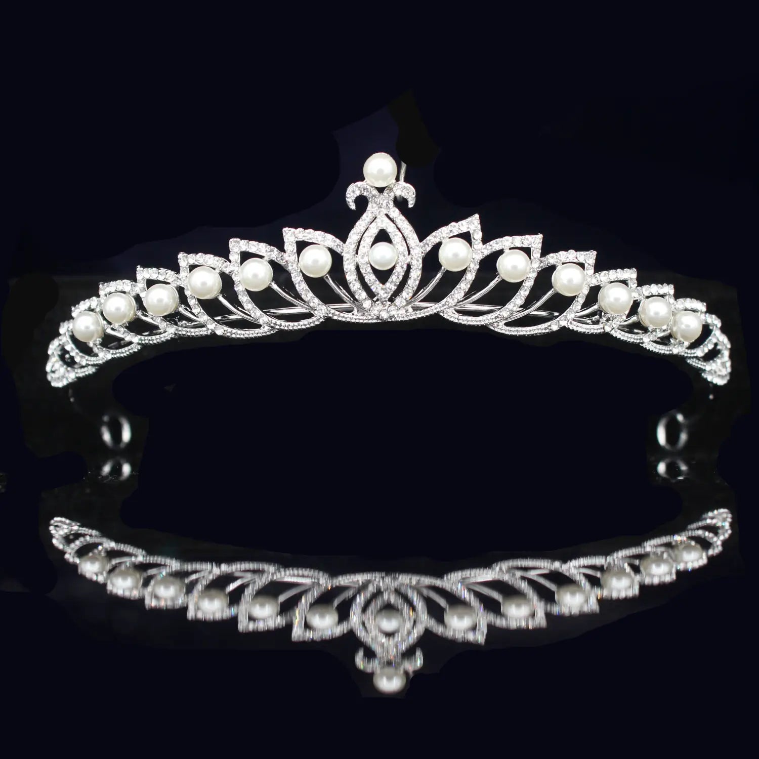 Una tiara de novia delicada de cristal plateado adornada con pedrería brillante y perlas blancas dispuestas de manera uniforme, con un elegante diseño floral inspirado en hojas.