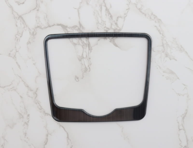Schwarze, rechteckige Einfassung des Audi A4 B9 A5 Schalthebel-Wandhalters für den Becherhalter mit Holzmaserungs-Textur und abgerundeten Ecken für das Armaturenbrett.