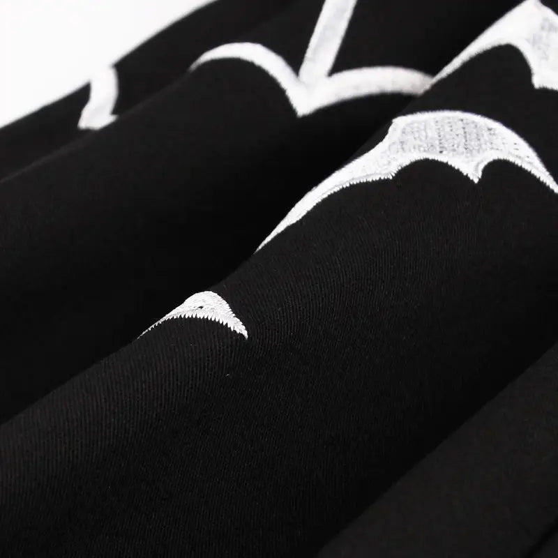 schwarze Leggings mit weißem Bat-Embroiderie-Detail, von vorn dargestellt, als Teil eines Ensembles aus einem Vintage-Bat-Embroiderie-A-Linien-Kleid