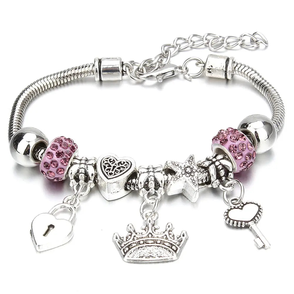Charm bracelet for women featuring a silver snake chain adorned with pink crystal beads and dangling crown, heart lock, starfish, and key charms.