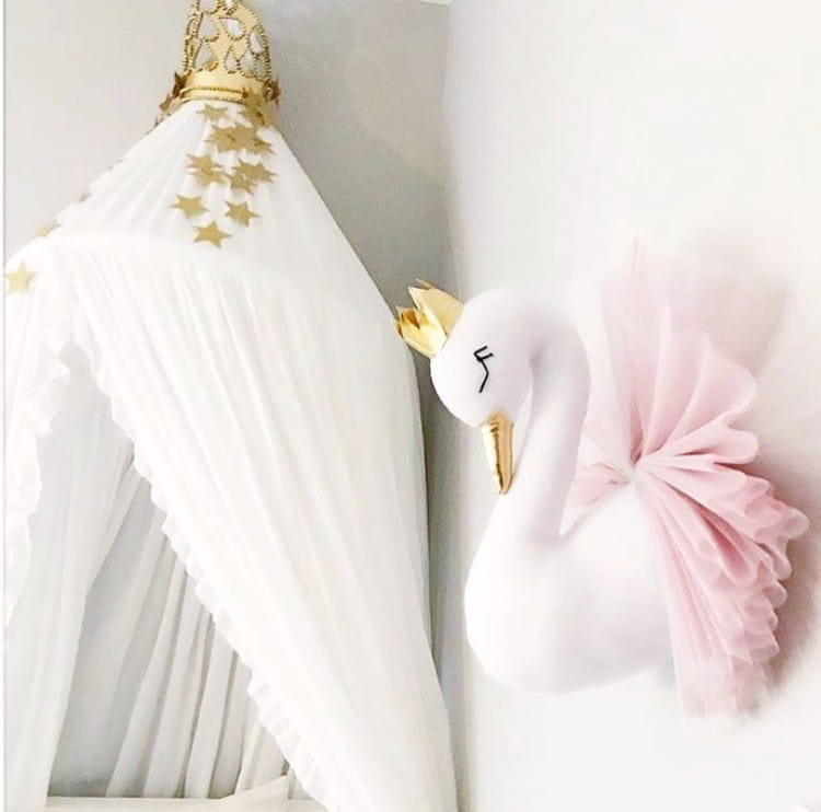 Eine plüschige weiße Schwan-3D-Cartoon-Tierkopf-Wanddekoration mit einer goldenen Krone und einem rosa Tüllschwanz.