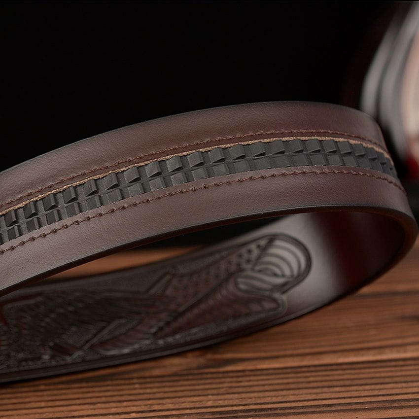 men’s leather ratchet belt with eagle buckle in brown featuring a textured woven pattern along the edge and an embossed design on the inner side.