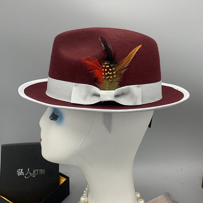 A unisex woolen felt fedora hat in maroon featuring a white satin ribbon bow and feather accent.