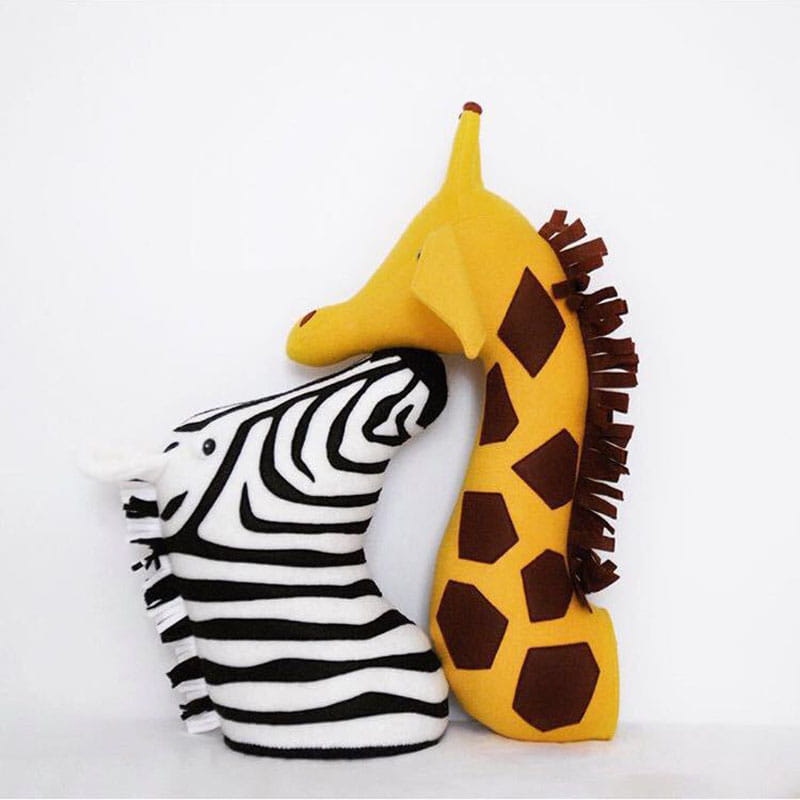 Ein gelbes Giraffenplüschtier mit braunen sechseckigen Flecken und einer fransigen Mähne, entworfen als 3D-Cartoon-Tierkopf-Wanddekoration.