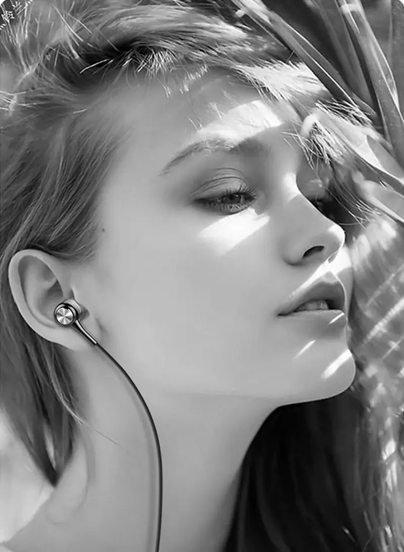 Écouteurs filaires intra-auriculaires avec une finition métallique élégante et un fil fin, conçus pour un usage sport, comprenant une prise jack 3,5 mm et un microphone intégré.