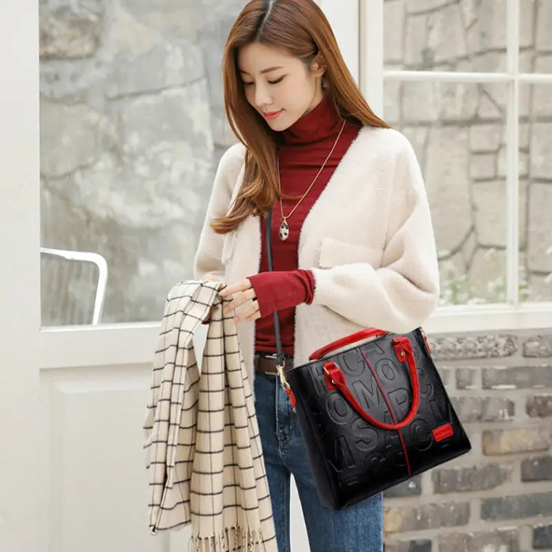 black crossbody handbag style1 style2 made of pu leather with red handles and embossed lettering satchel design