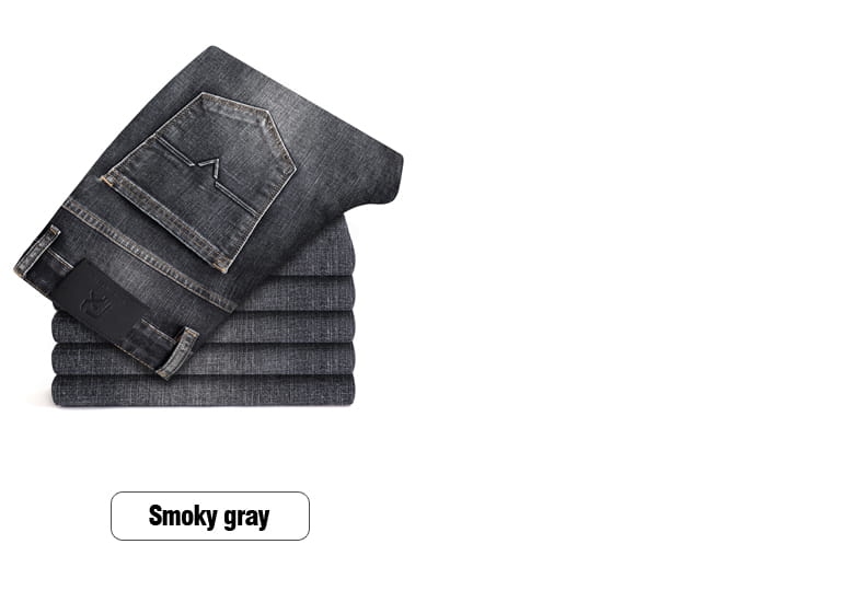 Jeans en denim stretch pour hommes, coupe regular fit, en gris fumé, avec un délavage légèrement décoloré et une couture classique, empilés avec soin.