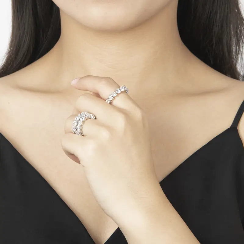 Une bague d’éternité cœur en argent sterling, dotée d’une bande argentée étincelante ornée d’une ligne continue de pierres facettées transparentes.