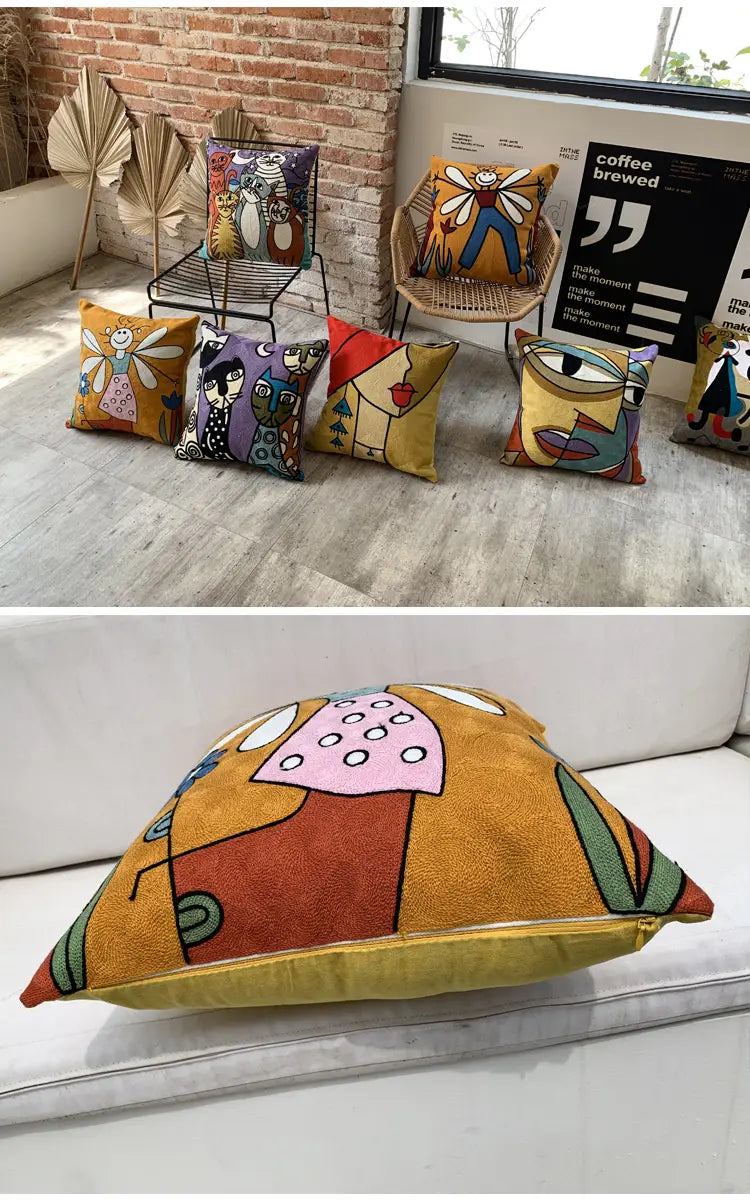 Housse de coussin jaune moutarde vive 45 x 45 cm avec des formes géométriques colorées abstraites brodées et des visages stylisés.