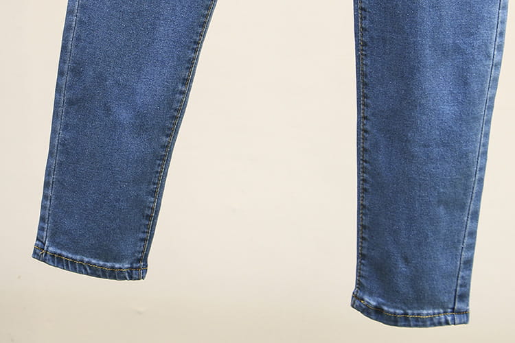 Jeans en denim bleu clair extensible taille haute à coupe slim, avec des poignets soigneusement cousus.