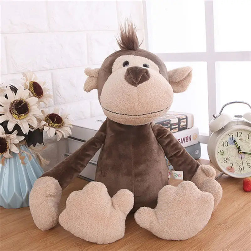 Singe en peluche brun rembourré, avec un visage beige clair et des mains réalisées en tissu de velours doux, ainsi que des détails cousus, inclus dans la collection de jouets lion éléphant tigre de la forêt.