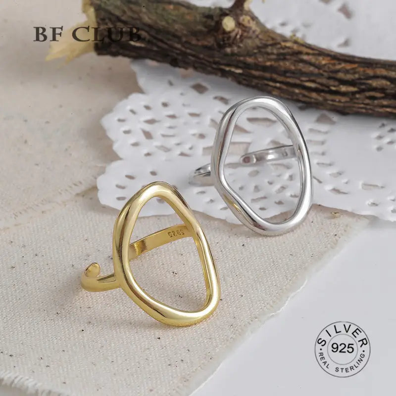 A pair of open modern geometric ring bands in gold and silver tones made from 925 sterling silver for women.