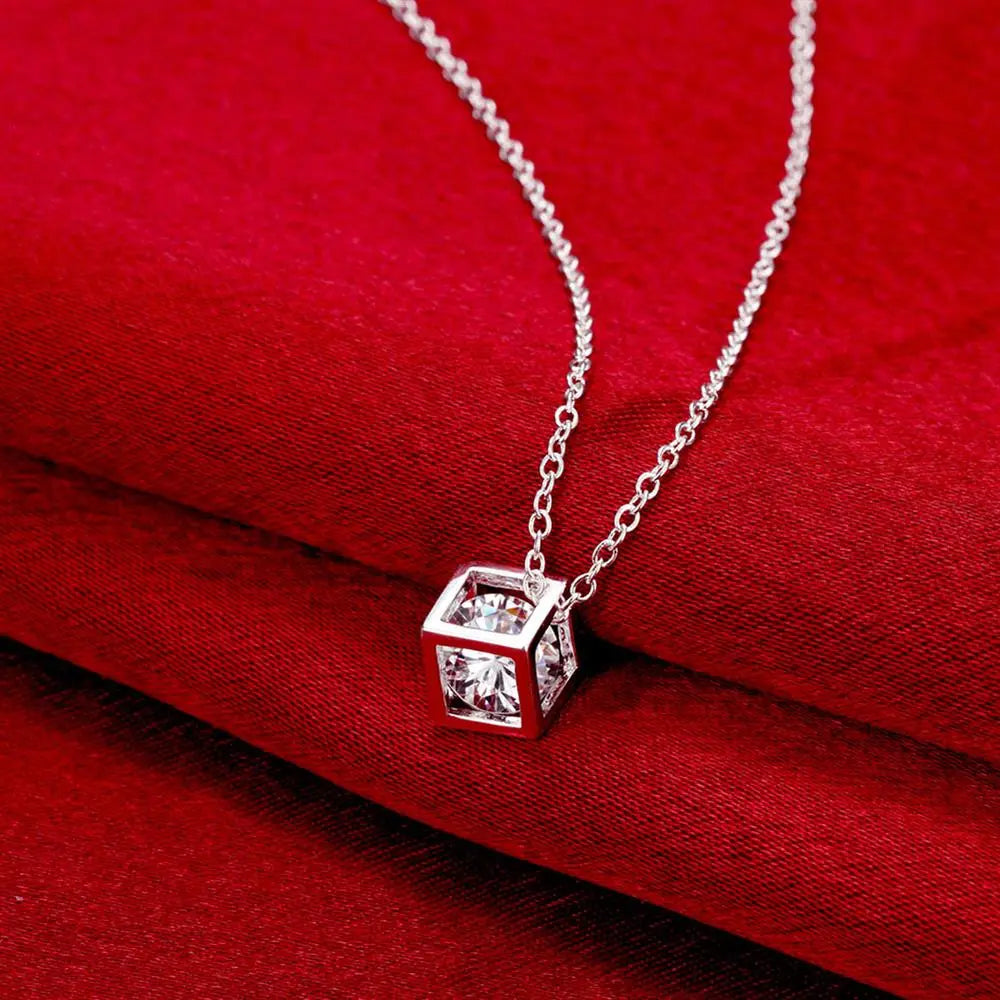 Collier de pendentif en zirconium carré argenté, avec un design de cube en argent, orné de pierres en zirconium cubiques transparentes, dans un style moderne et épuré.