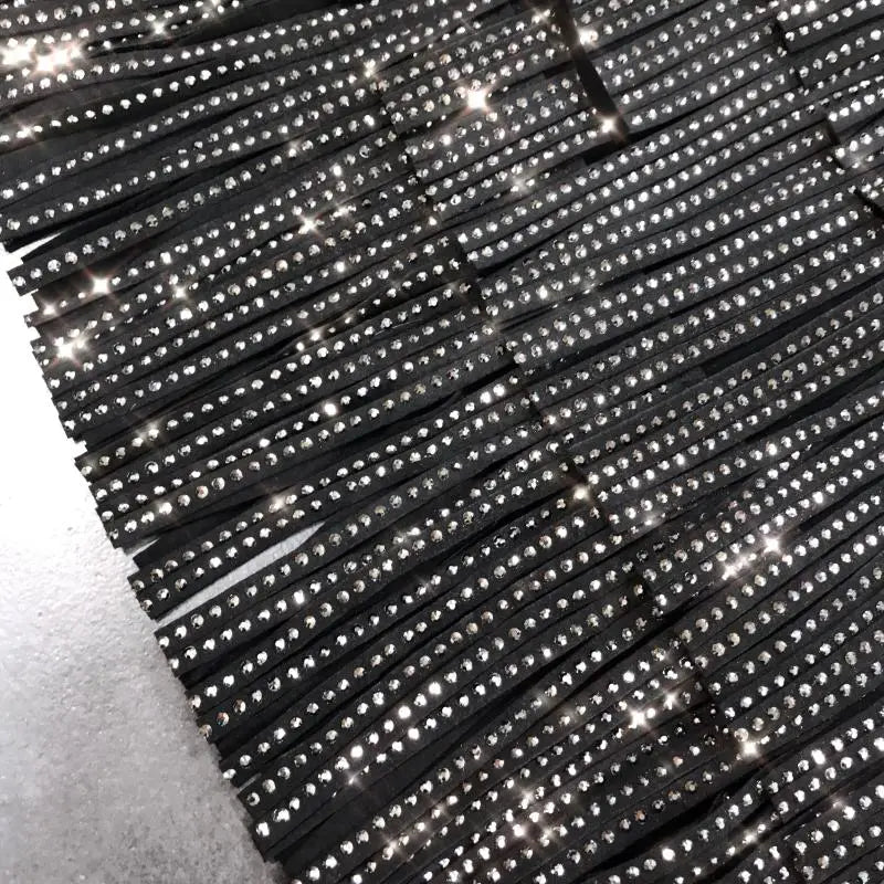 bordure noire à franges ornée de strass clairs scintillants sur une mini-jupe taille haute à franges en strass