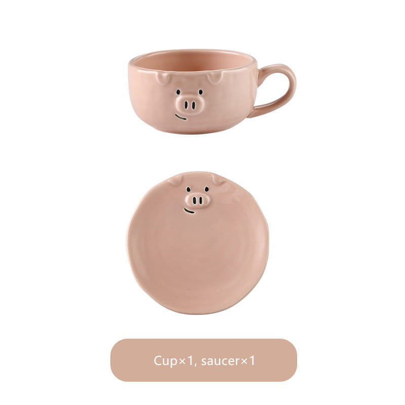 Pastel pink ceramic pig-shaped mug with matching saucer featuring simple black dot eyes and a smiling snout from the cute pig ceramic dinnerware set.