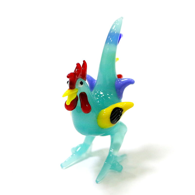 Vibrant turquoise glass rooster miniature figurine with red comb and wattle yellow beak wing accents and purple feather details used as an Easter ornament.