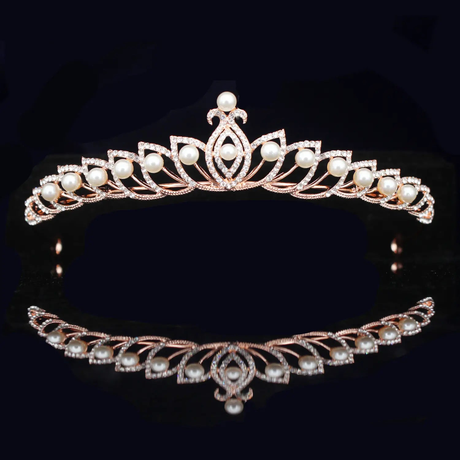 Una tiara de novia delicada de cristal rosa dorado adornada con perlas blancas y pedrería brillante en un elegante diseño simétrico de diadema floral para boda.