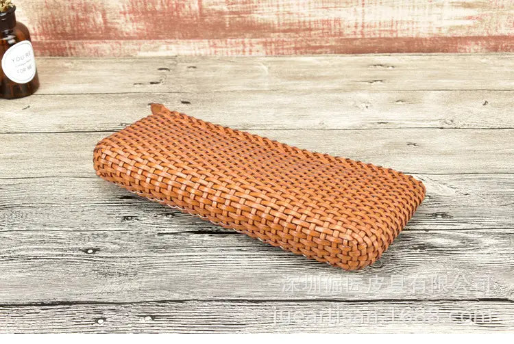 Une trousse rectangulaire en cuir tressé beige clair fabriquée en cuir véritable, adaptée à une utilisation comme embrasse en peau de vache en couches dans la collection de sacs à main en cuir tressé.