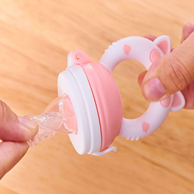 Pink and white silicone baby fruit feeder and teether set with cat ears design made of soft silicone for safe feeding and chewing.