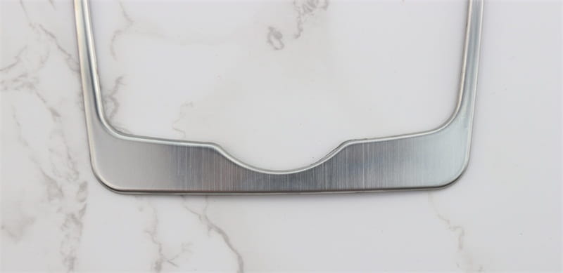 Rahmen für das Kennzeichen in Silberoptik aus Metall mit gebürstetem Finish und geschwungener Unterkante, ausgelegt für die Einfassung des Audi A4 B9 und A5 Schalthebel-Wandhalters für den Becherhalter.