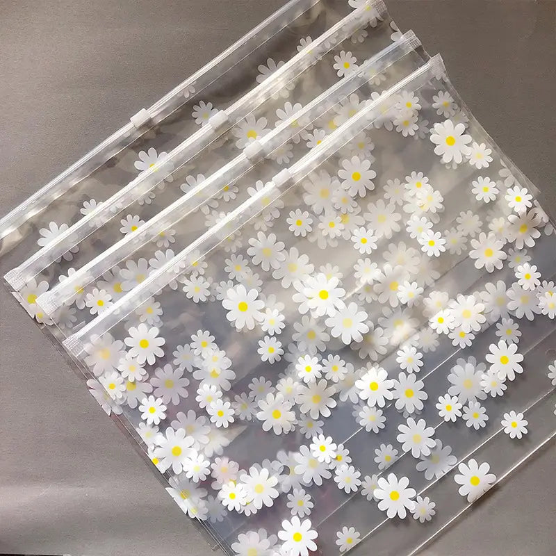 blumige, durchsichtige Reisekosmetiktasche aus durchsichtigem Kunststoff mit Reißverschlussbeuteln, verziert mit einem Muster aus weißen Gänseblümchen mit gelben Zentren