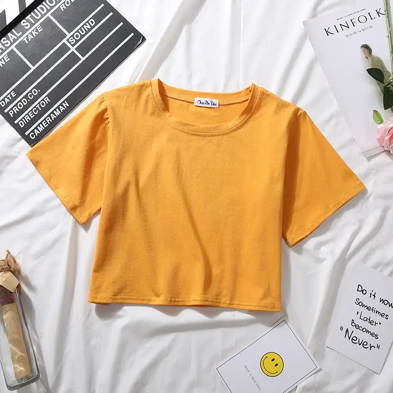 A vibrant yellow women solid short sleeve crop top casual t-shirt made of soft cotton fabric with a round neckline.